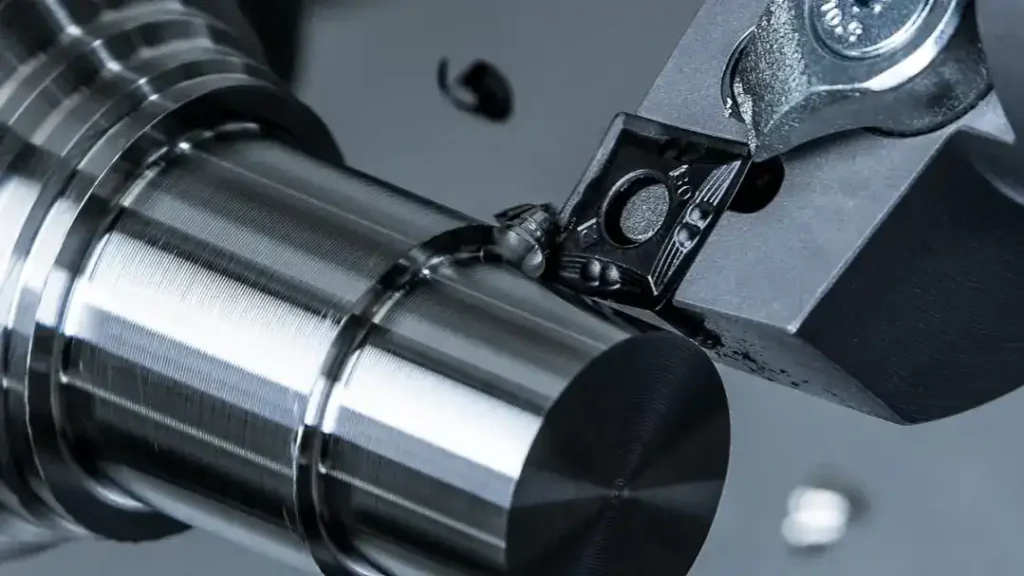 CNC lathe turning a carbide indexable insert, demonstrating turning insert geometry on a steel workpiece
